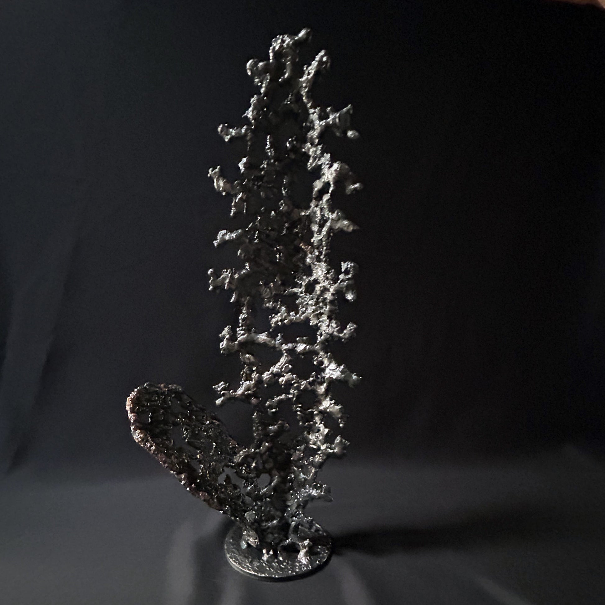 Sculpture abstraite de Philippe Buil : dentelle de métal en acier et bronze, reflets irisées et formes ajourées, œuvre unique contemporaine.