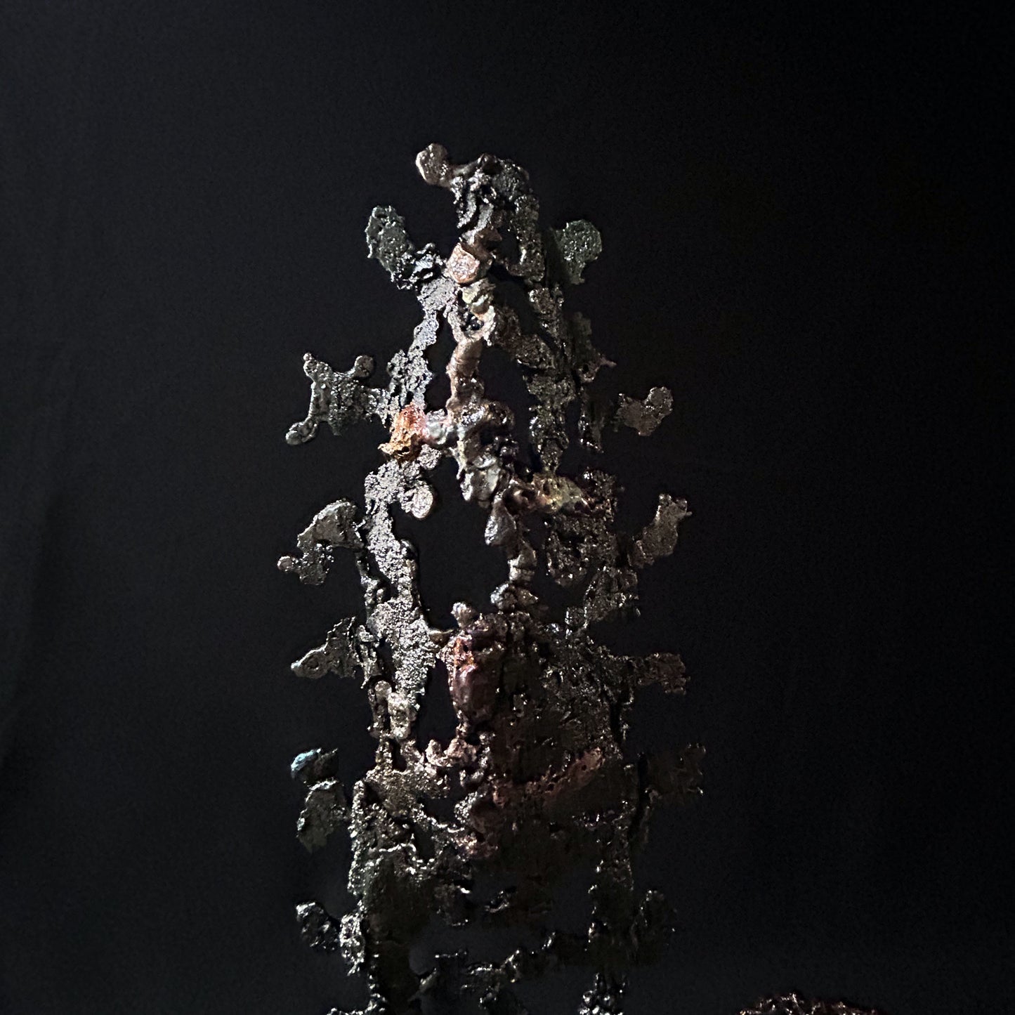 Sculpture abstraite de Philippe Buil : dentelle de métal en acier et bronze, reflets irisées et formes ajourées, œuvre unique contemporaine.