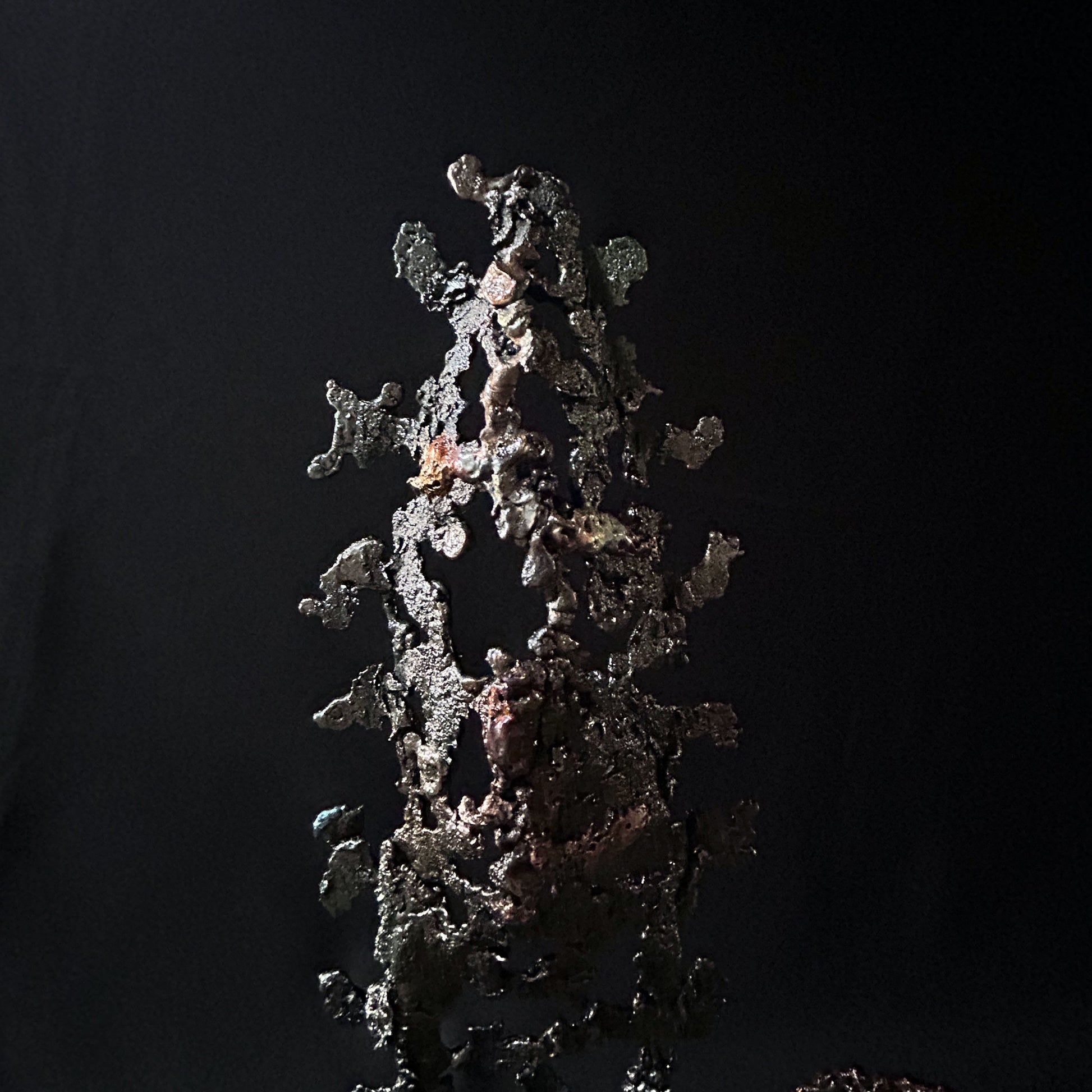 Sculpture abstraite de Philippe Buil : dentelle de métal en acier et bronze, reflets irisées et formes ajourées, œuvre unique contemporaine.