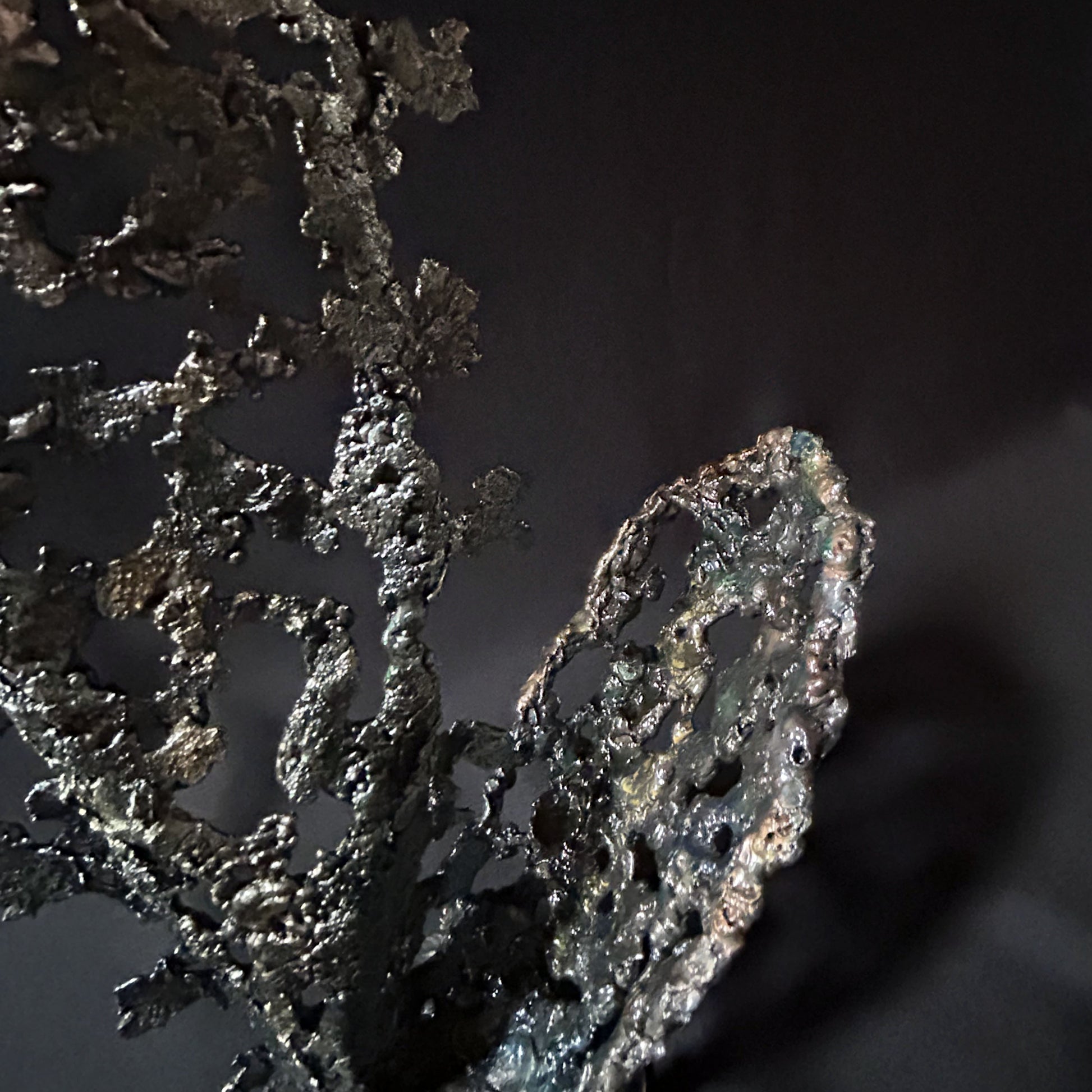 Sculpture abstraite de Philippe Buil : dentelle de métal en acier et bronze, reflets irisées et formes ajourées, œuvre unique contemporaine.