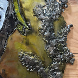 Sculpture murale en acier réalisée par Philippe Buil, représentant un visage de clown inspiré de Bernard Buffet, avec dentelle de métal et pigments colorés.