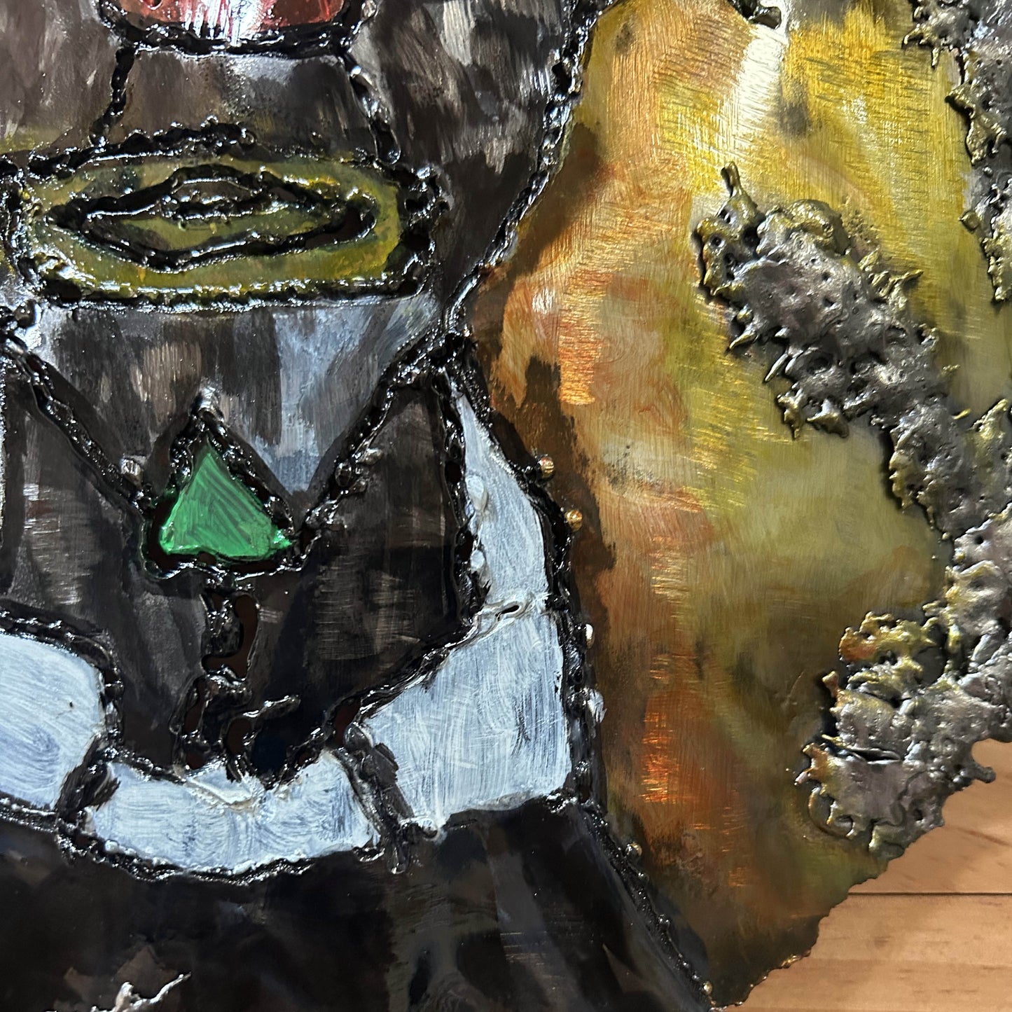 Sculpture murale en acier réalisée par Philippe Buil, représentant un visage de clown inspiré de Bernard Buffet, avec dentelle de métal et pigments colorés.