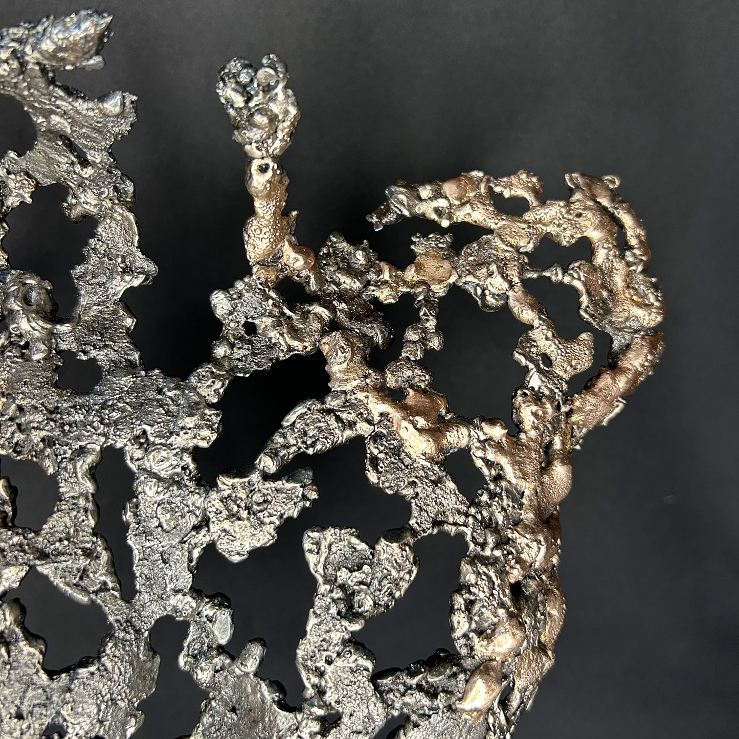 Vue rapprochée de la texture acier et bronze de la sculpture Les Seuils du Jour