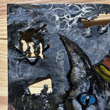 Sculpture murale de Philippe Buil sur tôle d’acier découpée, dentelle de métal et pigments : un chat arlequin expressif au regard bleu hypnotique.