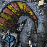 Sculpture murale de Philippe Buil sur tôle d’acier découpée, dentelle de métal et pigments : un chat arlequin expressif au regard bleu hypnotique.