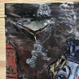 Sculpture murale en métal de Philippe Buil représentant un chien portant un béret et un foulard basque, avec pigments colorés et fond texturé sombre