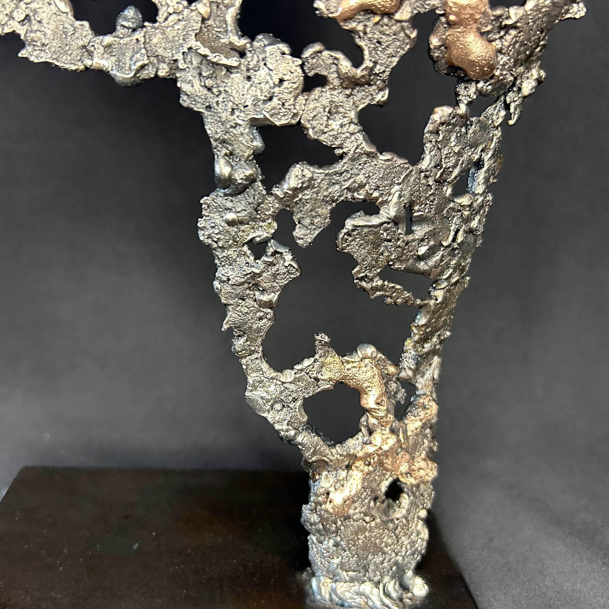 Détail Sculpture contemporaine Belisama Le Souffle de Philippe Buil, buste de femme à taille réelle en dentelle de métal acier et bronze avec étoiles fondues,  sur fond sombre.